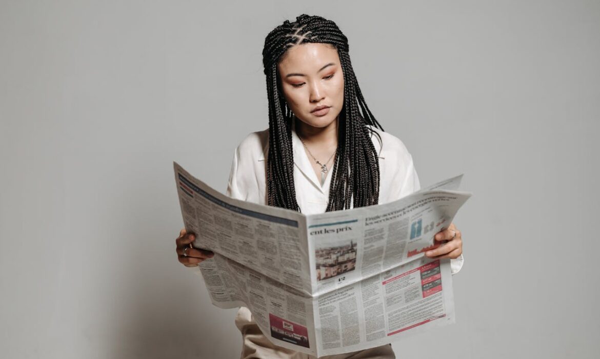 Business professional reviewing financial news publication to research press release distribution strategies