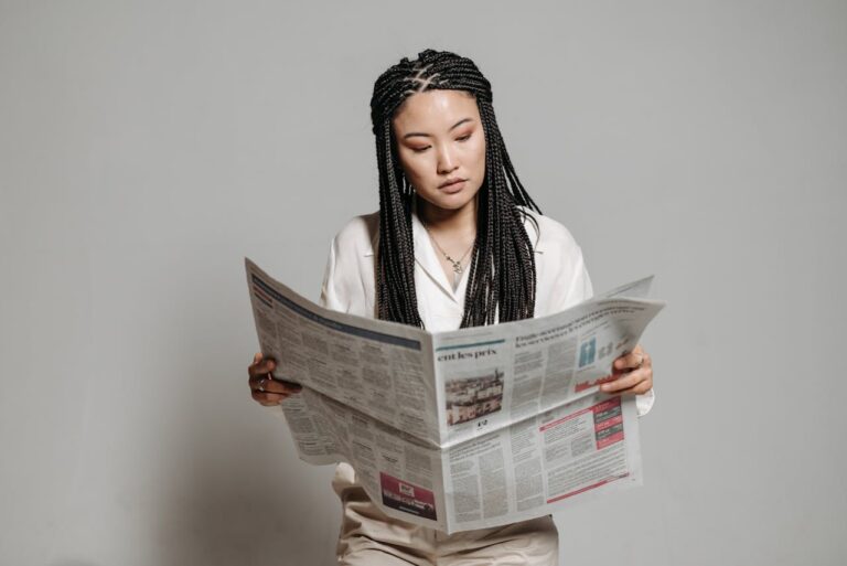 Business professional reviewing financial news publication to research press release distribution strategies