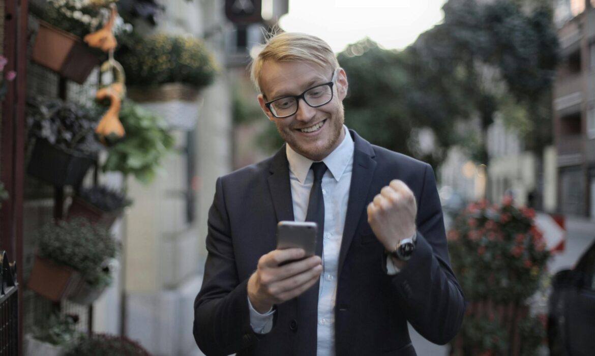 Entrepreneur celebrating success on phone after getting featured on Entrepreneur Magazine - Nextenco guaranteed placement service